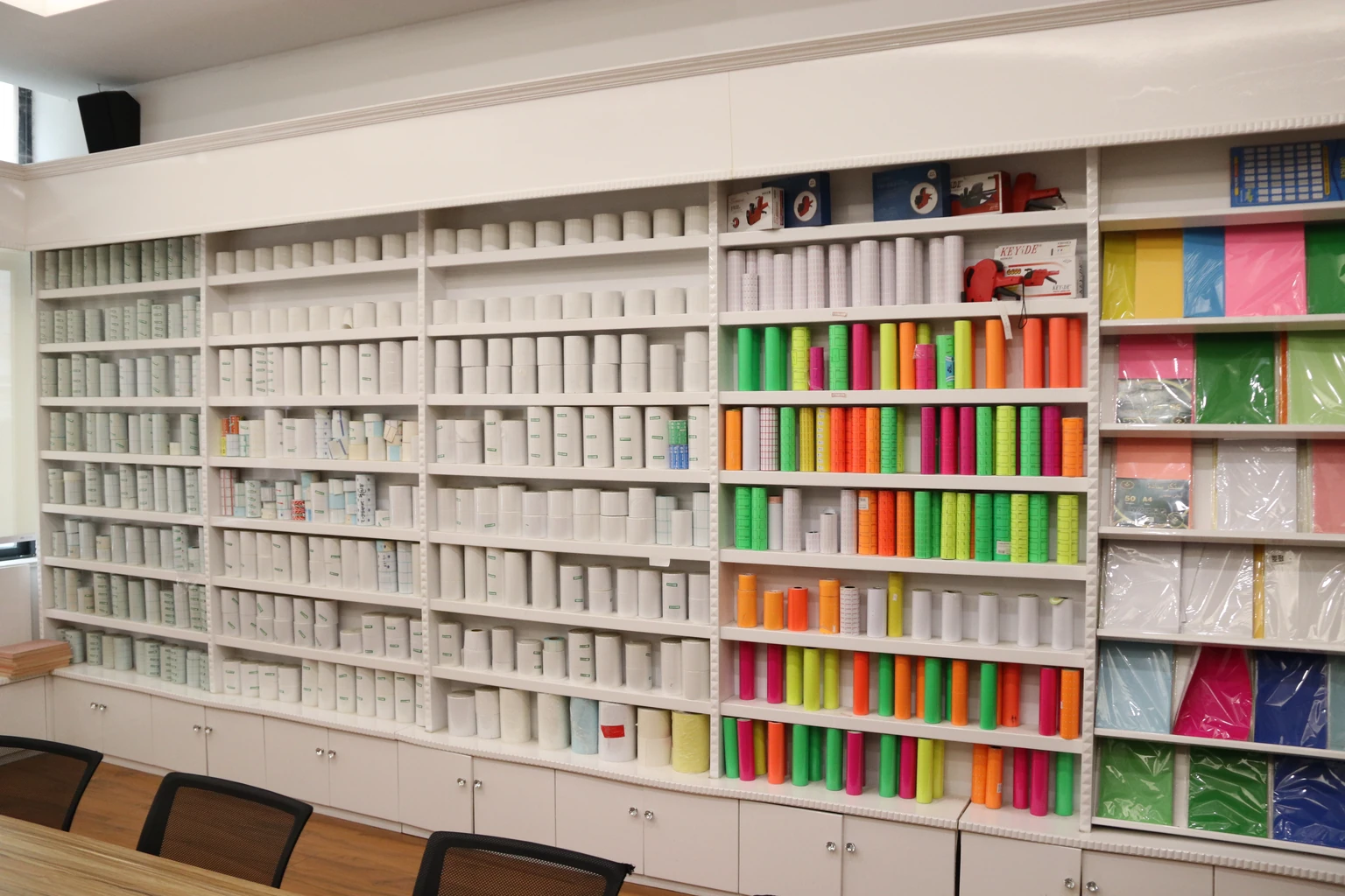 Shelves displaying white and coloured label rolls and paper samples