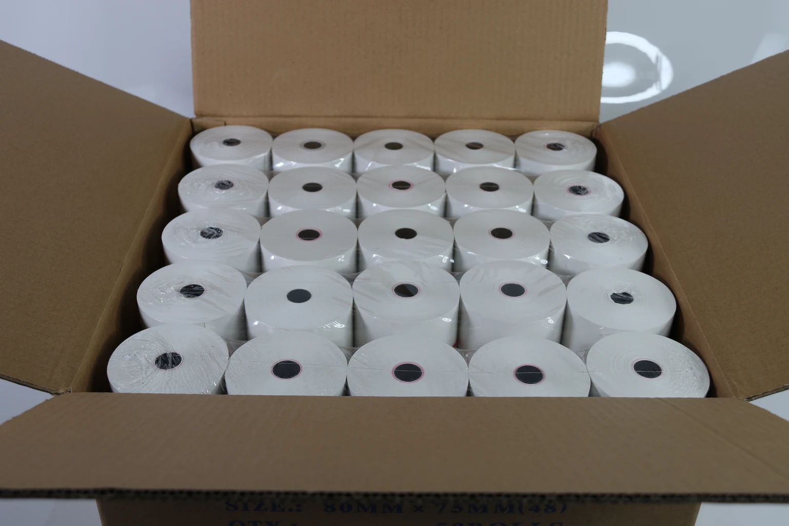 wrapped receipt-paper rolls inside a carton