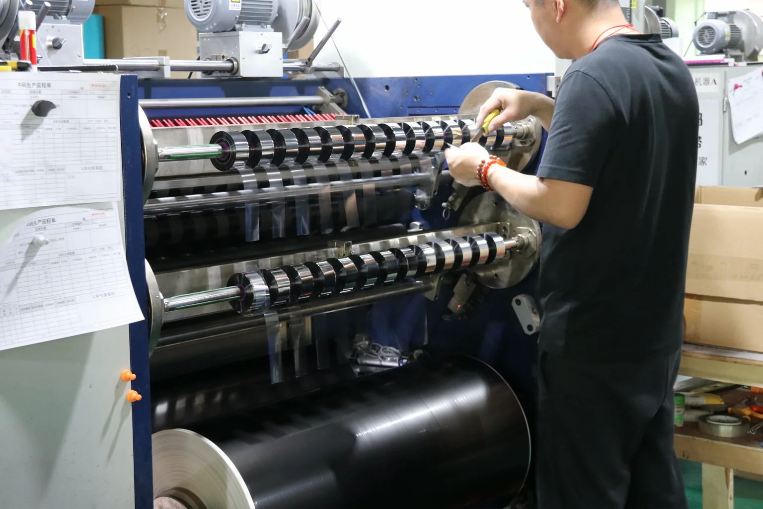 A member of the production team working beside ribbon converting equipment